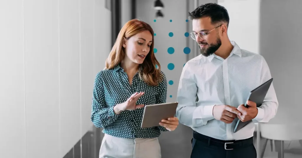 Financial planning professionals discussing client strategy on a tablet.