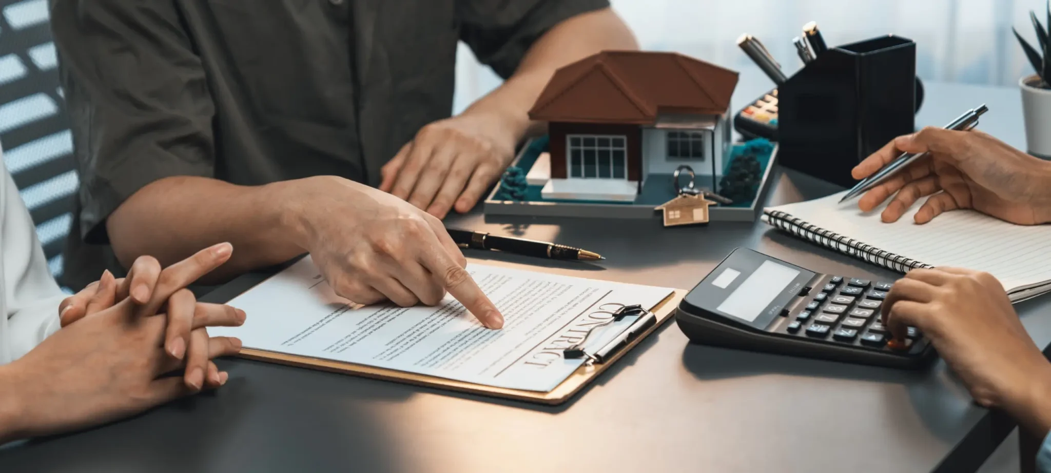Mortgage broker reviewing a home loan contract with clients.